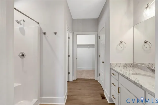 a bathroom with a granite countertop shower sink and mirror