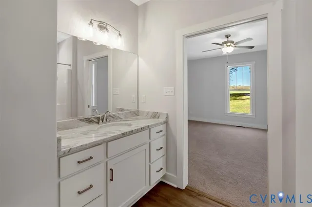 a bathroom with a granite countertop sink a light fixture and a mirror