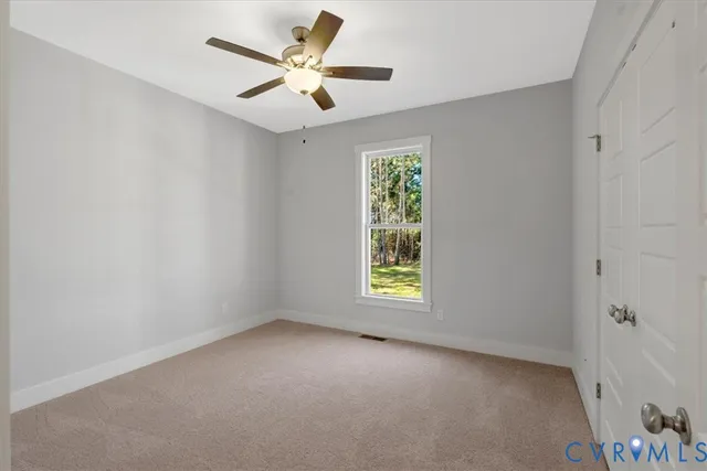 an empty room with a window and a fan