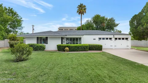 a view of a house with a yard and potted plants