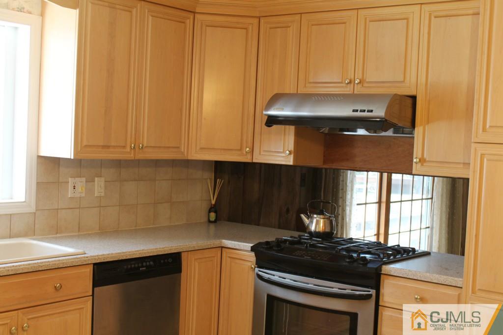10 Greenwich Road Edison, NJ 08820 - Photo 7 of 25 a kitchen with granite countertop a stove a sink and a microwave