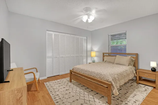 a view of a house with a big yard and palm trees
