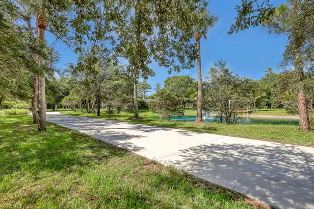 a view of swimming pool with lawn chairs and a big yard