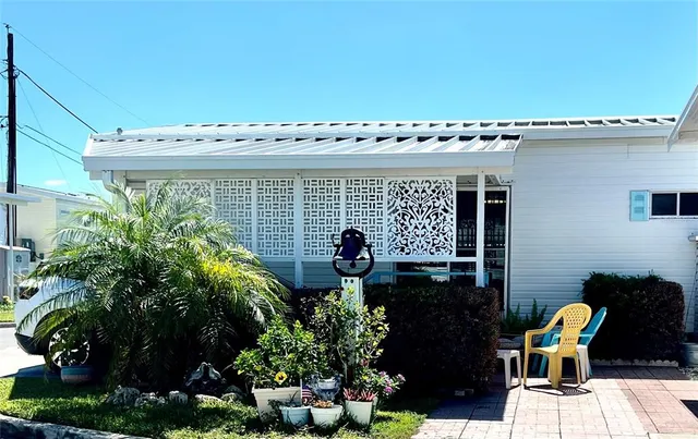 a front view of a house with lots of potted plants