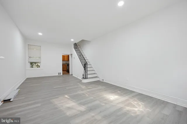 a view of an empty room with stairs and a window