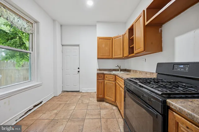 a kitchen with granite countertop a stove and a sink