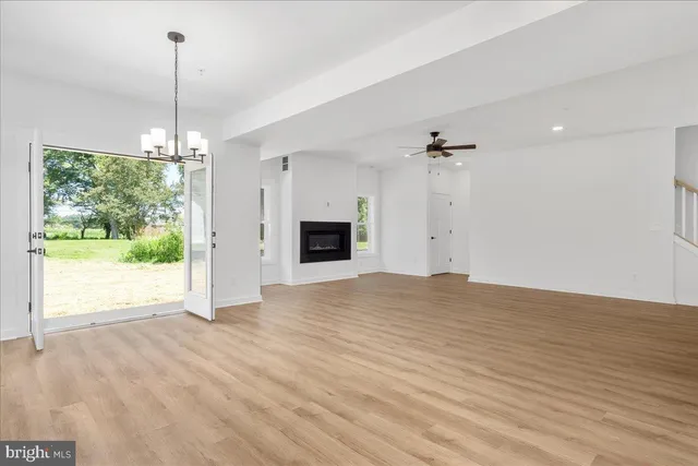 a view of an empty room with a fireplace and a window