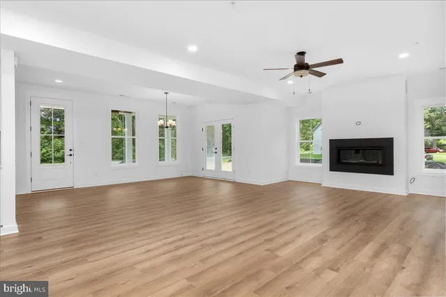 an empty room with windows fireplace and a sink