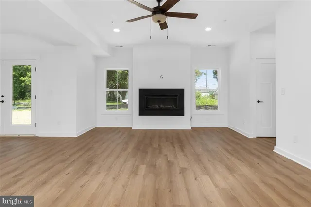 an empty room with windows and a fireplace