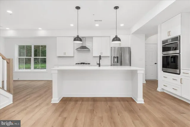 a view of a kitchen with wooden floor and a sink