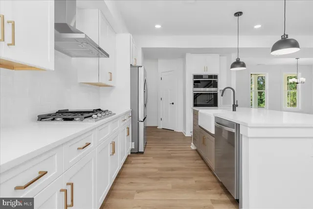 a kitchen with kitchen island a stove a sink a refrigerator and chairs