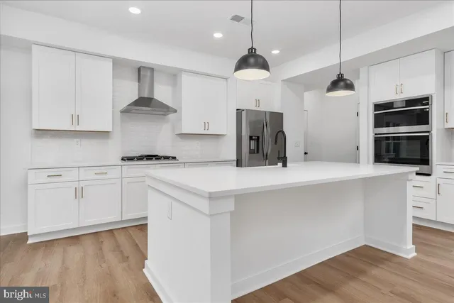 a kitchen with kitchen island a sink stainless steel appliances and cabinets