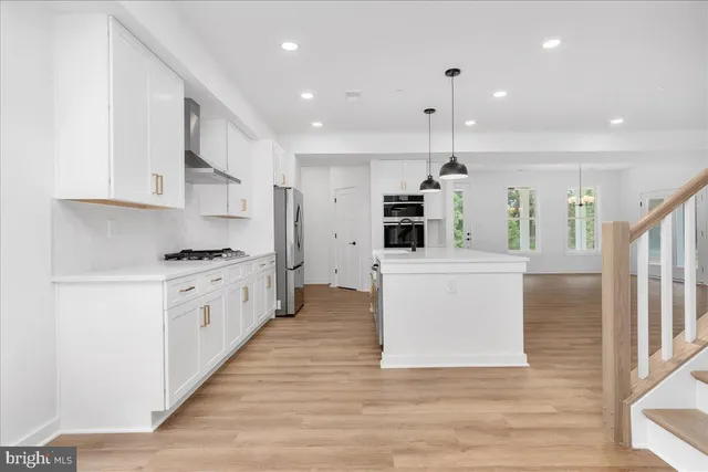 a kitchen with stainless steel appliances kitchen island wooden cabinets and a refrigerator