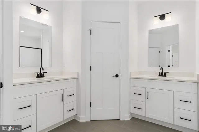 a bathroom with double sink a toilet and a mirror