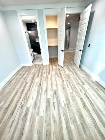 a view of a hallway with wooden floor and staircase
