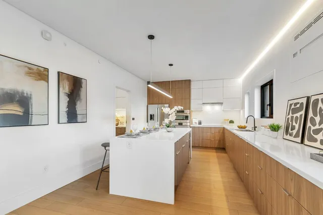 a living room with furniture large window and wooden floor