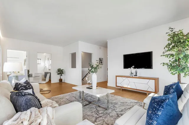 a living room with furniture and view of kitchen