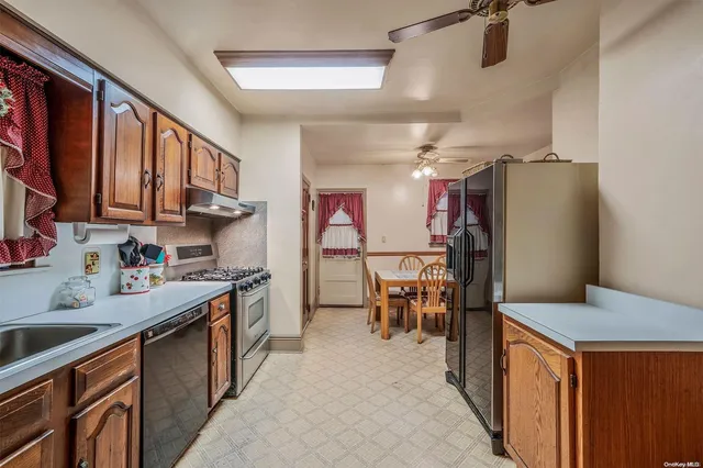 a kitchen with stainless steel appliances granite countertop a refrigerator a sink dishwasher a stove and a dining table with wooden cabinet