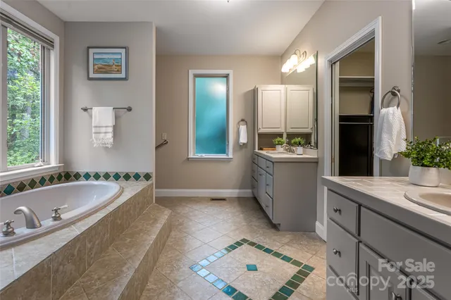 a bathroom with a granite countertop tub sink and mirror