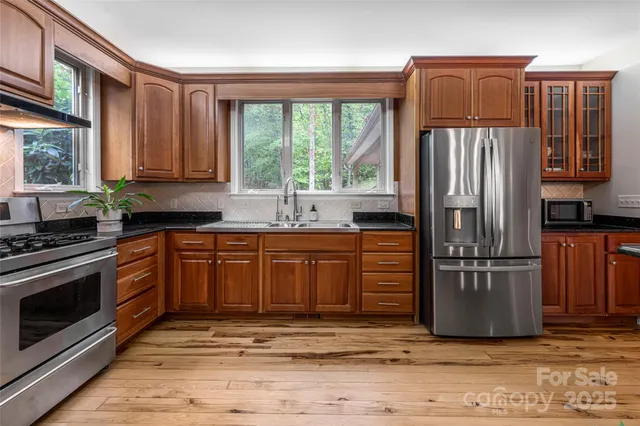 a kitchen with stainless steel appliances granite countertop a refrigerator stove and sink