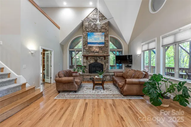 a living room with furniture a fireplace and a floor to ceiling window