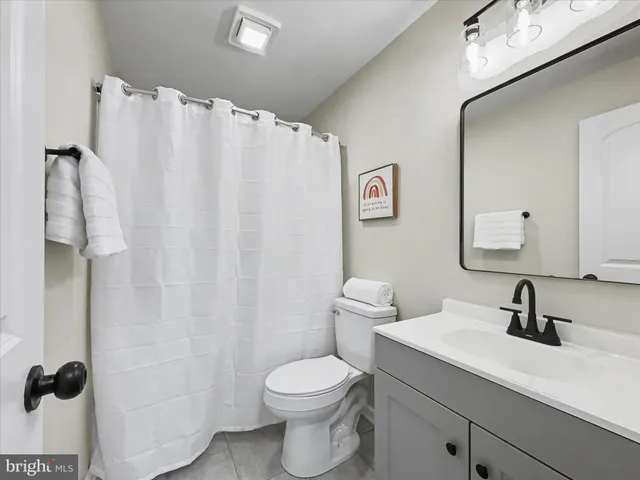a bathroom with a sink mirror vanity and toilet
