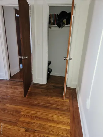 an empty room with wooden floor and closet