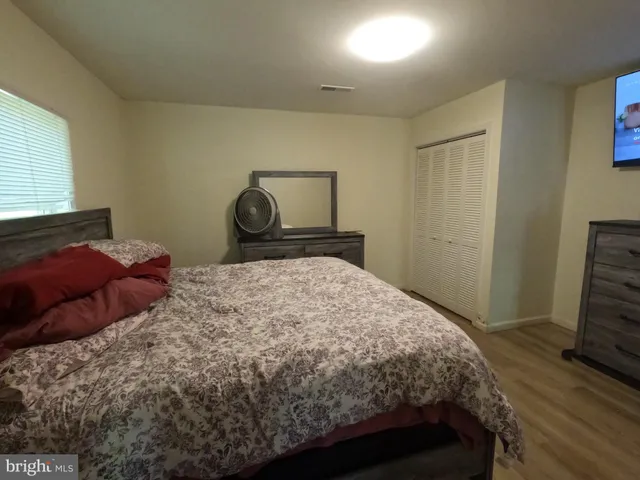a bedroom with a bed and a tv on the dresser