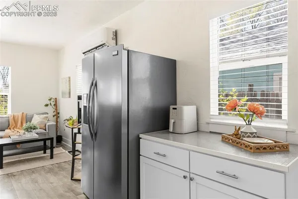a kitchen with stainless steel appliances granite countertop a refrigerator white cabinets and a dishwasher