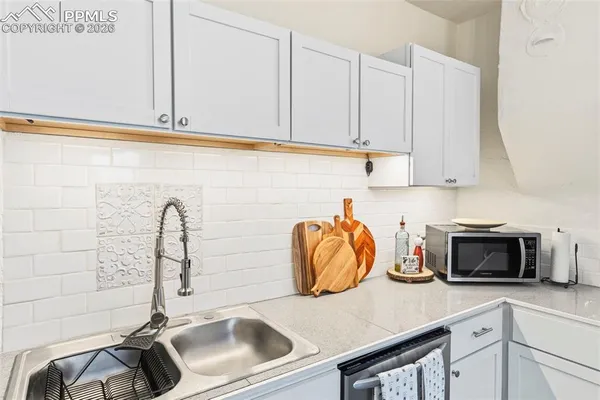 a kitchen with stainless steel appliances granite countertop a sink and a white cabinets