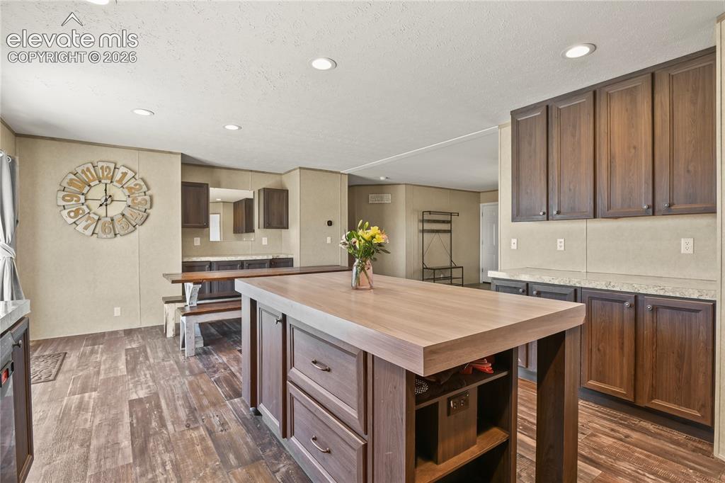 22280 Jones Road Peyton, CO 80831 - Photo 13 of 47 a kitchen with a stove a sink a kitchen island with wooden cabinets and entryway