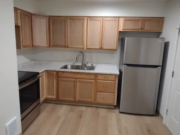 a kitchen with a sink a refrigerator and cabinets