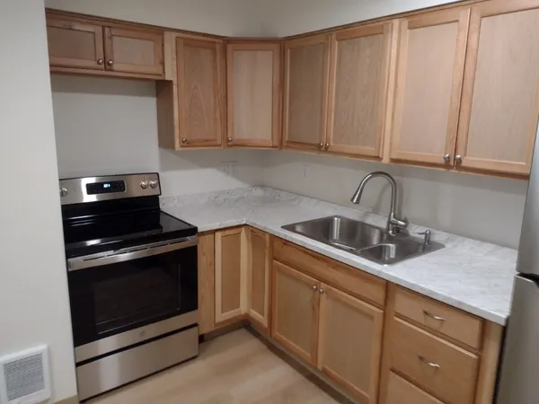 a kitchen with granite countertop white cabinets and stainless steel appliances