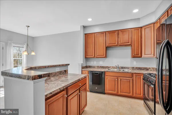 a kitchen with stainless steel appliances granite countertop a stove a refrigerator and a sink
