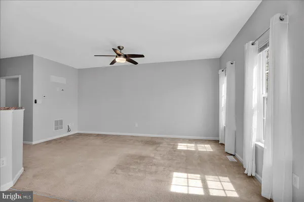 a view of a room with a ceiling fan and window