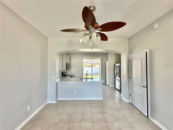 a view of a livingroom and a chandelier fan and windows