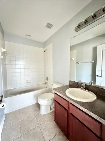 a bathroom with a double vanity sink a mirror a bathtub and next to a window