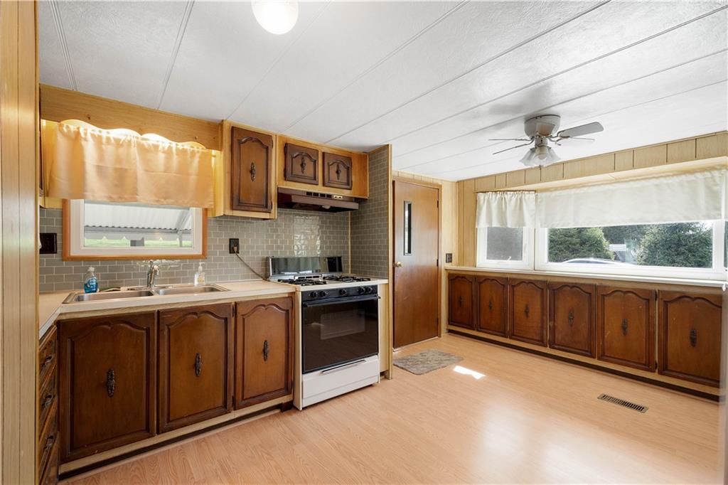 269 Rainey Road Eighty Four, PA 15330 - Photo 14 of 28 a kitchen with stainless steel appliances granite countertop a sink a stove cabinets and wooden floor