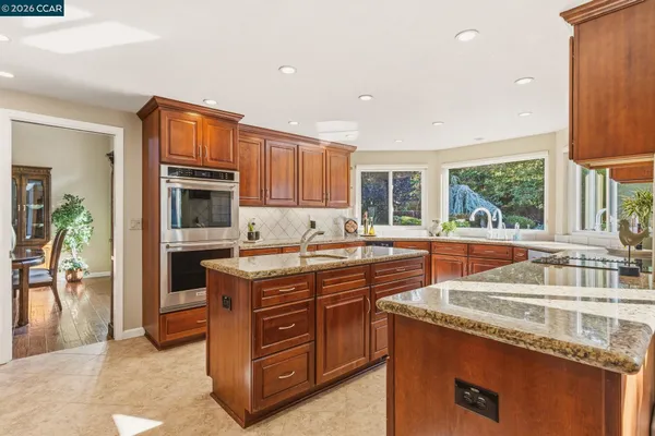 a kitchen with granite countertop a sink stove and cabinets