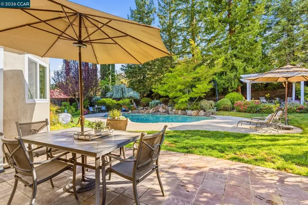 a view of a patio with table and chairs under an umbrella