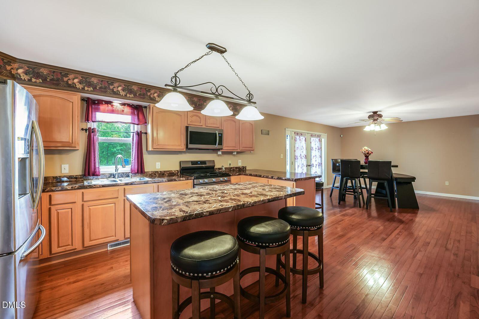 376-t K T K Allen Road Louisburg, NC 27549 - Photo 9 of 49 a kitchen with stainless steel appliances granite countertop table chairs stove and wooden floor