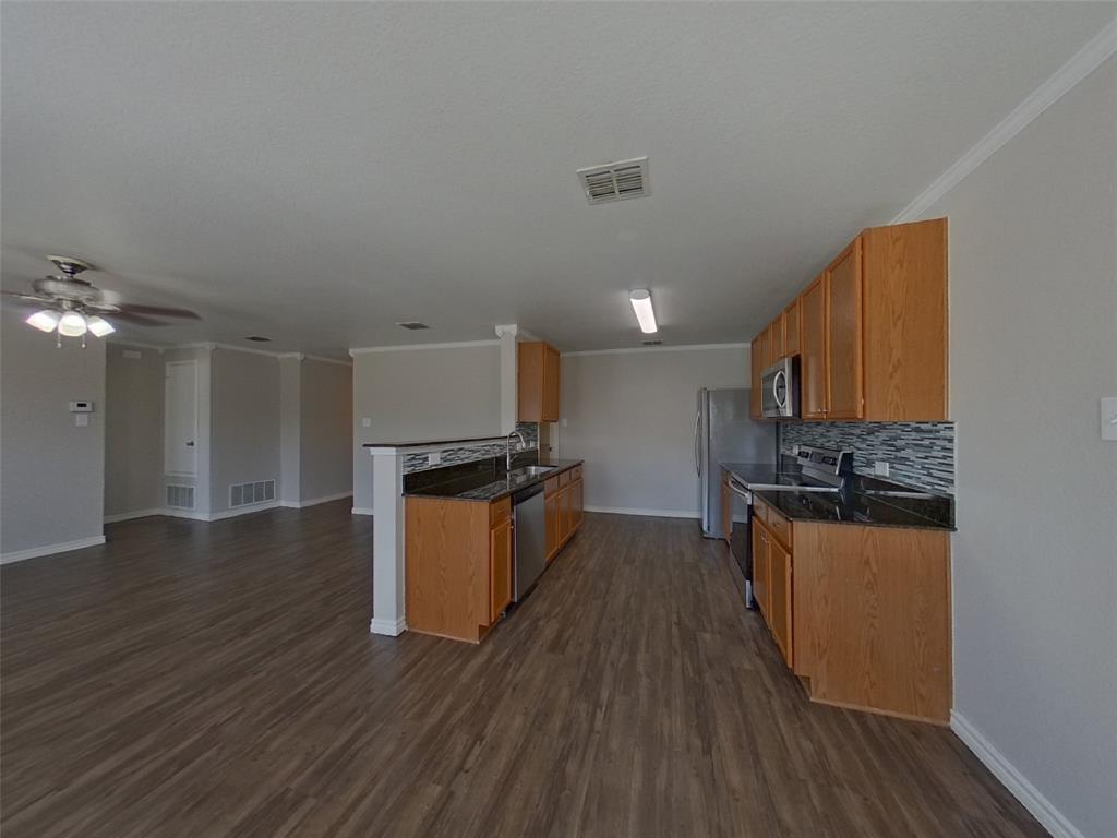 1448 Castle Ridge Road Fort Worth, TX 76140 - Photo 3 of 16 a kitchen with stainless steel appliances granite countertop a stove a sink dishwasher and a refrigerator with wooden floor