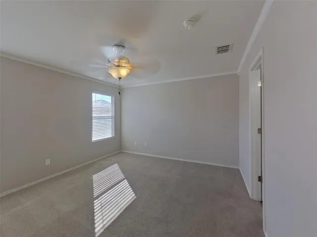 an empty room with windows and ceiling fan