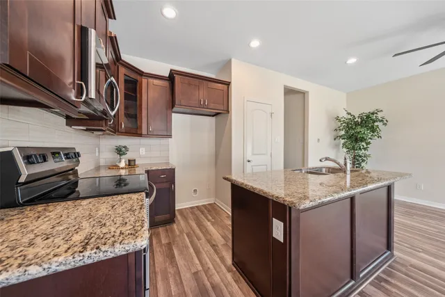 a kitchen with stainless steel appliances granite countertop a sink stove and refrigerator
