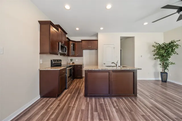a kitchen with stainless steel appliances granite countertop a stove a sink and a refrigerator