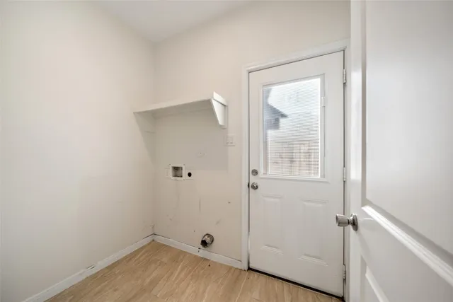 a view of a small space with wooden floor and a window