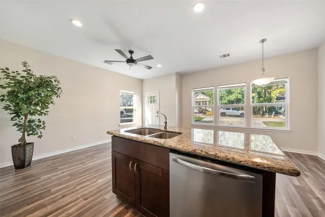 a kitchen with granite countertop a sink a counter space and a window