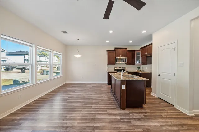 a kitchen with stainless steel appliances granite countertop a refrigerator and a stove top oven