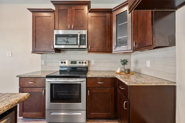 a kitchen with stainless steel appliances granite countertop a stove microwave and sink