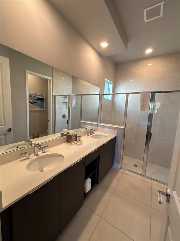 7740 Sandy Ridge Drive, Unit 131 Reunion, FL 34747 - Photo 12 of 27 a bathroom with a double vanity sink and mirror